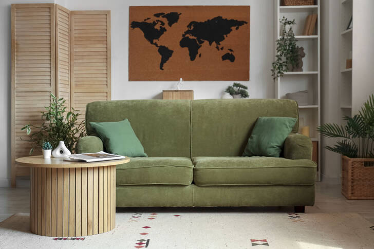 Living cu o canapea verde și mobilier din lemn