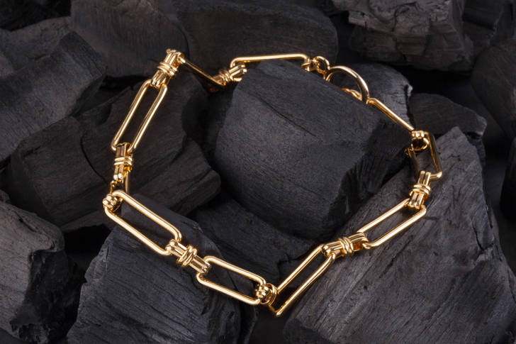 Gold bracelet on black coal