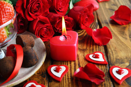 Roses, candies and a heart-shaped candle