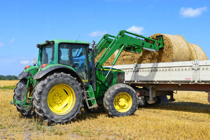 Tractor in the field loads straw