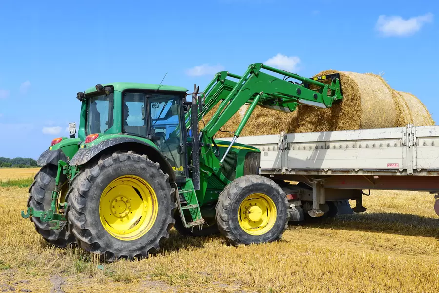 Traktor põllul laadib põhku