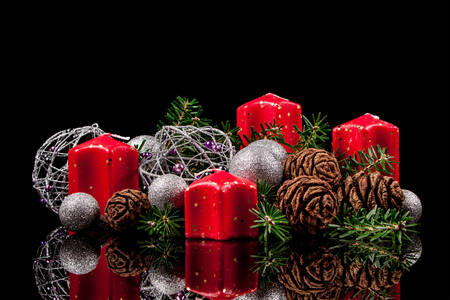 Kerzen und Weihnachtsspielzeug auf schwarzem Hintergrund