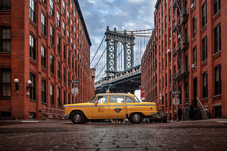 Táxi com a Ponte de Manhattan ao fundo