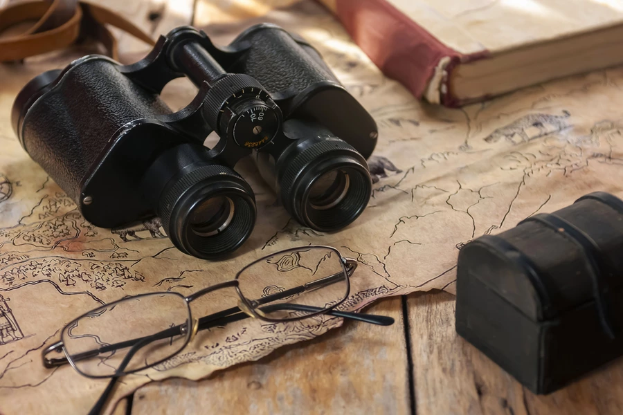 Jumelles et lunettes sur une vieille carte