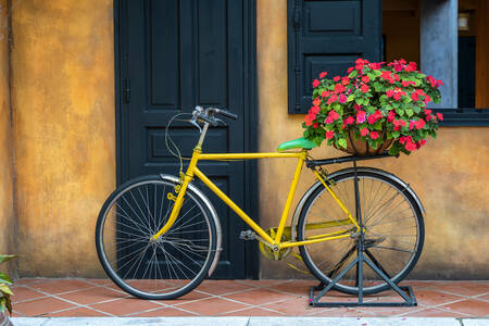 Żółty rower z koszem kwiatów