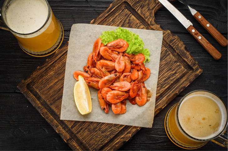 Beer and fried shrimp on wooden board