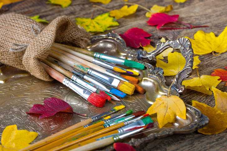 Brushes and autumn leaves on the table