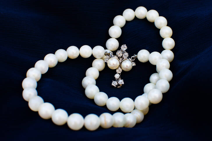 Halskette mit Perlen auf blauem Hintergrund