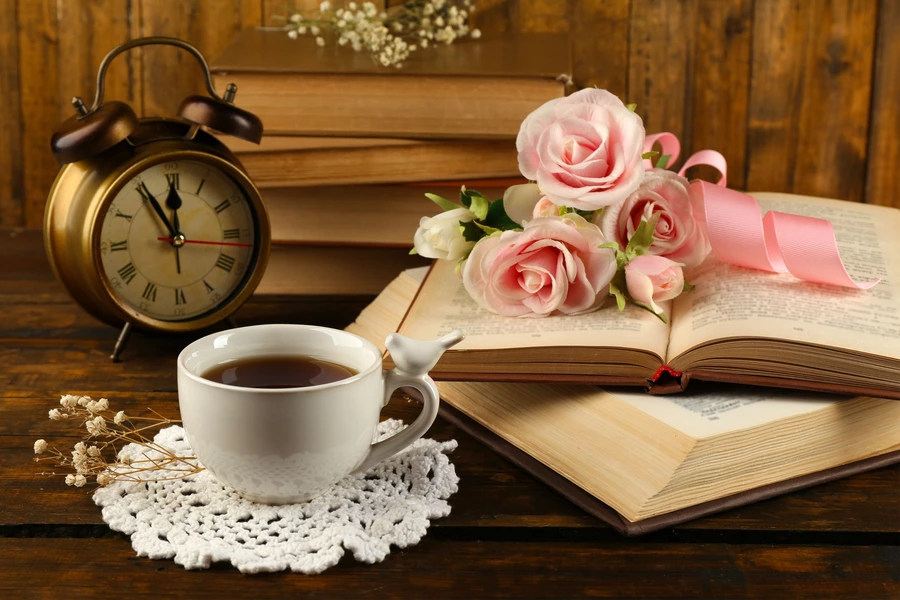Reloj, taza de té y flores.