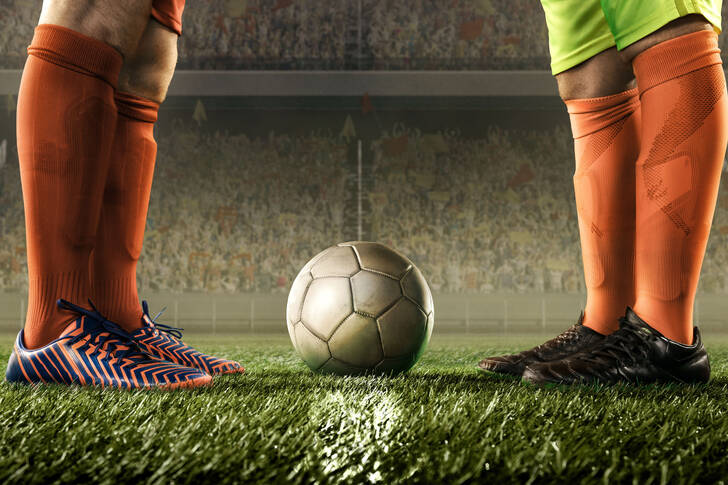 Football players' legs and the ball