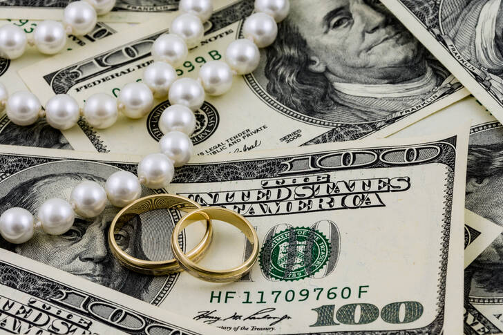 Dollars, a necklace, and gold rings