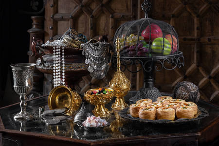 Oriental sweets and fruits on a glass table