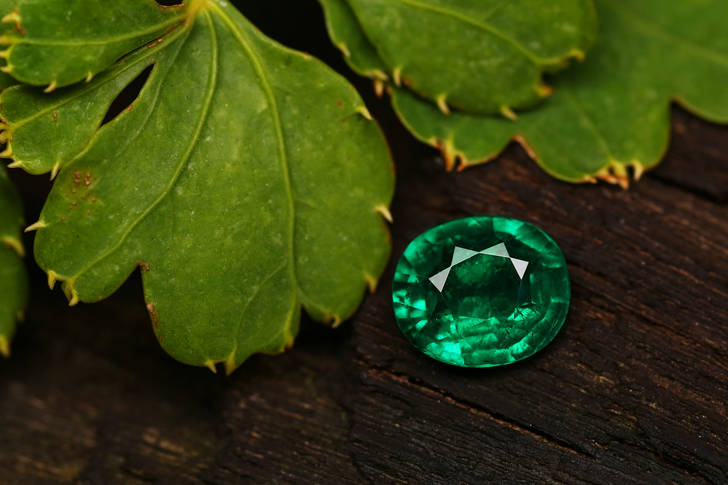 Emerald on wooden background