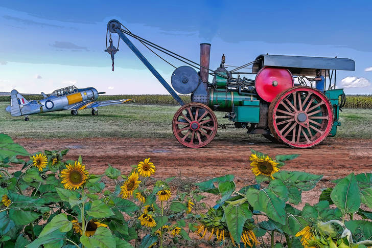 Steam tractor and airplane in the field