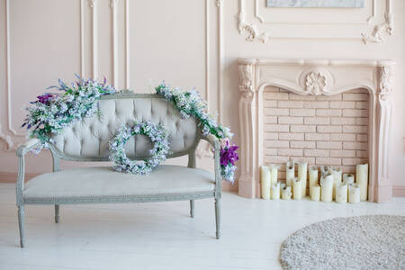 Sofa with flowers by the fireplace