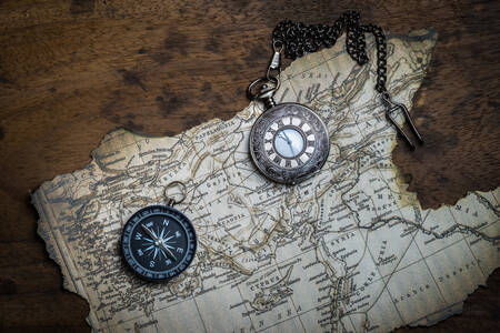 Compass and pocket watch on the map