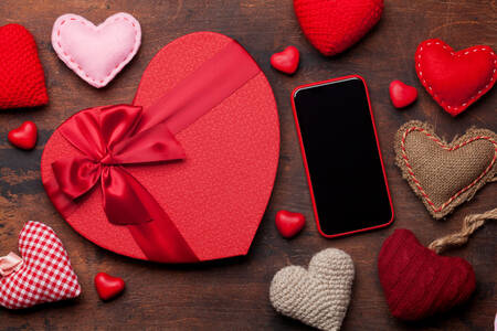 Corações e smartphone em cima da mesa