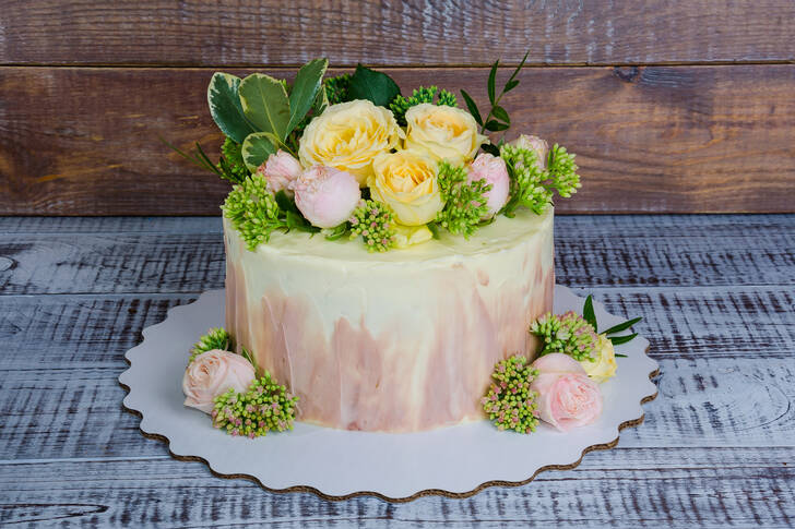 Gâteau de mariage avec des roses sur la table