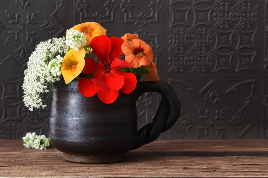 Bukett blommor i en mörk kopp
