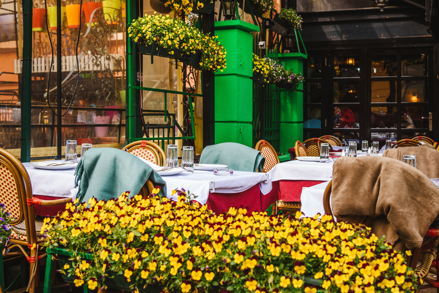 Straatcafés verstrengeld met bloemen
