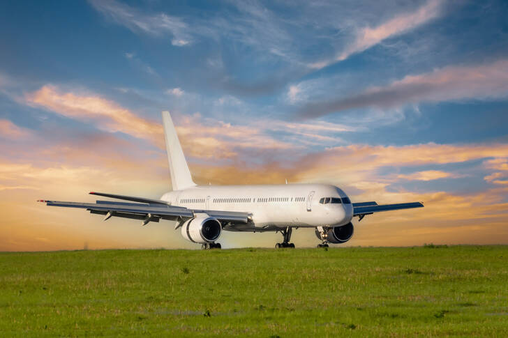 A passenger plane in a green field