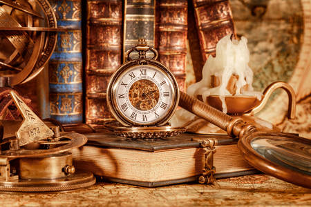 Livro antigo, bússola e relógio de bolso