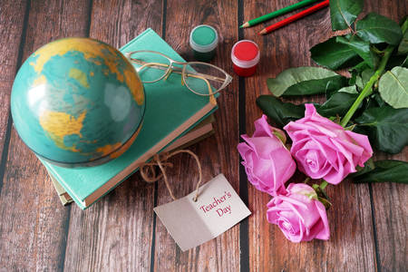 Livros, globo e rosas na mesa