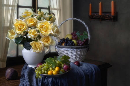 Rose gialle e frutti sul tavolo