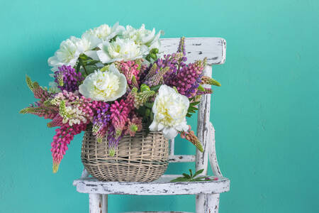 Un panier avec des fleurs sur une chaise