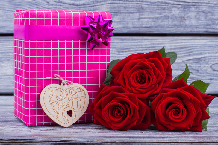 A gift and roses on the table