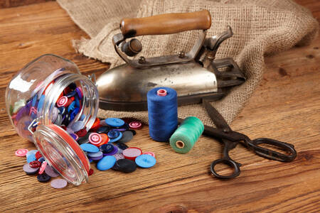 Iron, scissors and buttons on the table