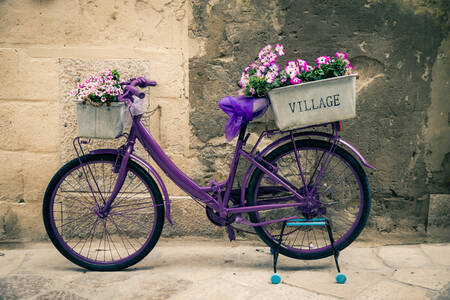 Paarse fiets met bloemen