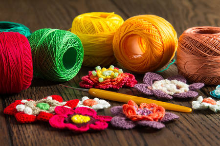 Threads, crochet hook and knitted flowers