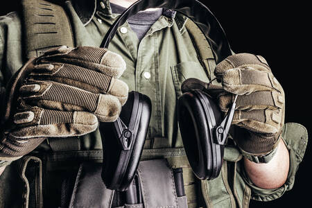 Shooting headphones in the hands of a soldier