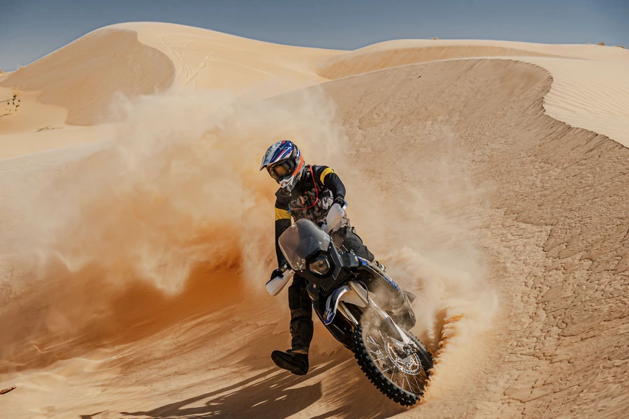 Un motocycliste roule à travers les dunes de sable